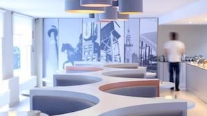 A modern interior with curved seating areas and pendant lighting. - The Grey Hotel (Dortmund)