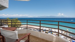 Uma varanda com vista para o mar, a praia e as montanhas.