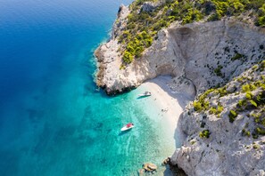 A coastal cliff with a beach and clear turquoise waters. - Lido Hotel (Xylokastro-Evrostina)