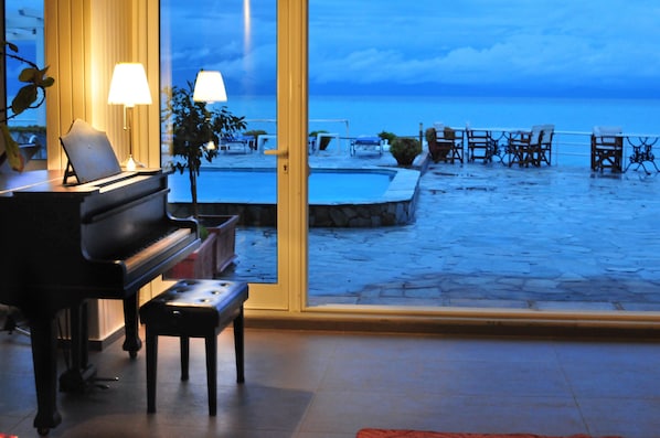 Un piano en una habitación con vistas a una piscina y una playa.