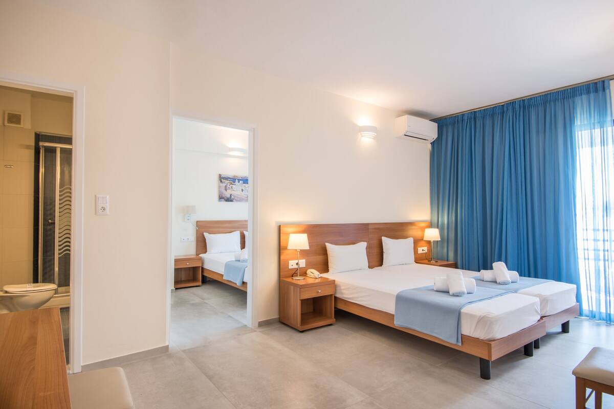 Une chambre d’hôtel avec un grand lit, des tables de chevet, une salle de bain et une vue sur l’extérieur.