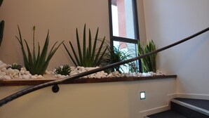 A staircase with a railing, surrounded by various plants and white pebbles. - The Originals City, Hôtel des Arts (Negrepelisse)