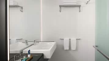 Un baño moderno con dos lavamanos, un espejo y toalleros.