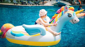 A person on a unicorn float in a swimming pool.