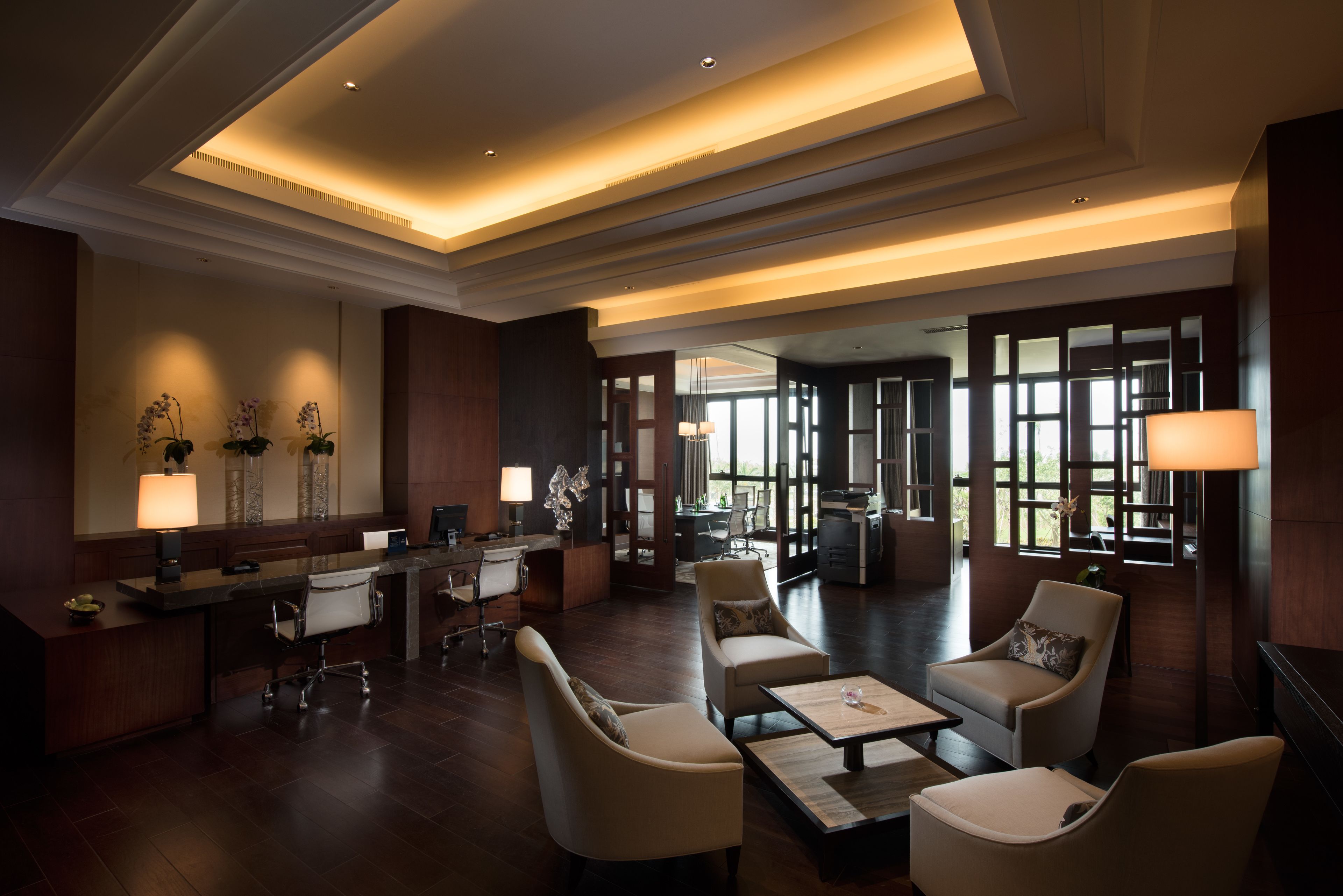 A spacious lobby with a reception desk, comfortable seating, and large windows allowing natural light.