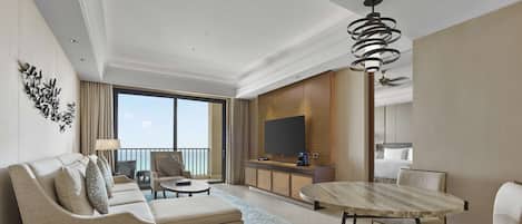 A modern hotel room with a balcony, a dining area, a sofa set, and a TV.