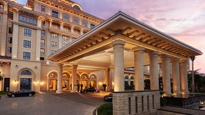 A grand hotel entrance with a covered patio, large columns, and a well-lit facade. - Hilton Haikou Meilan (Haikou)