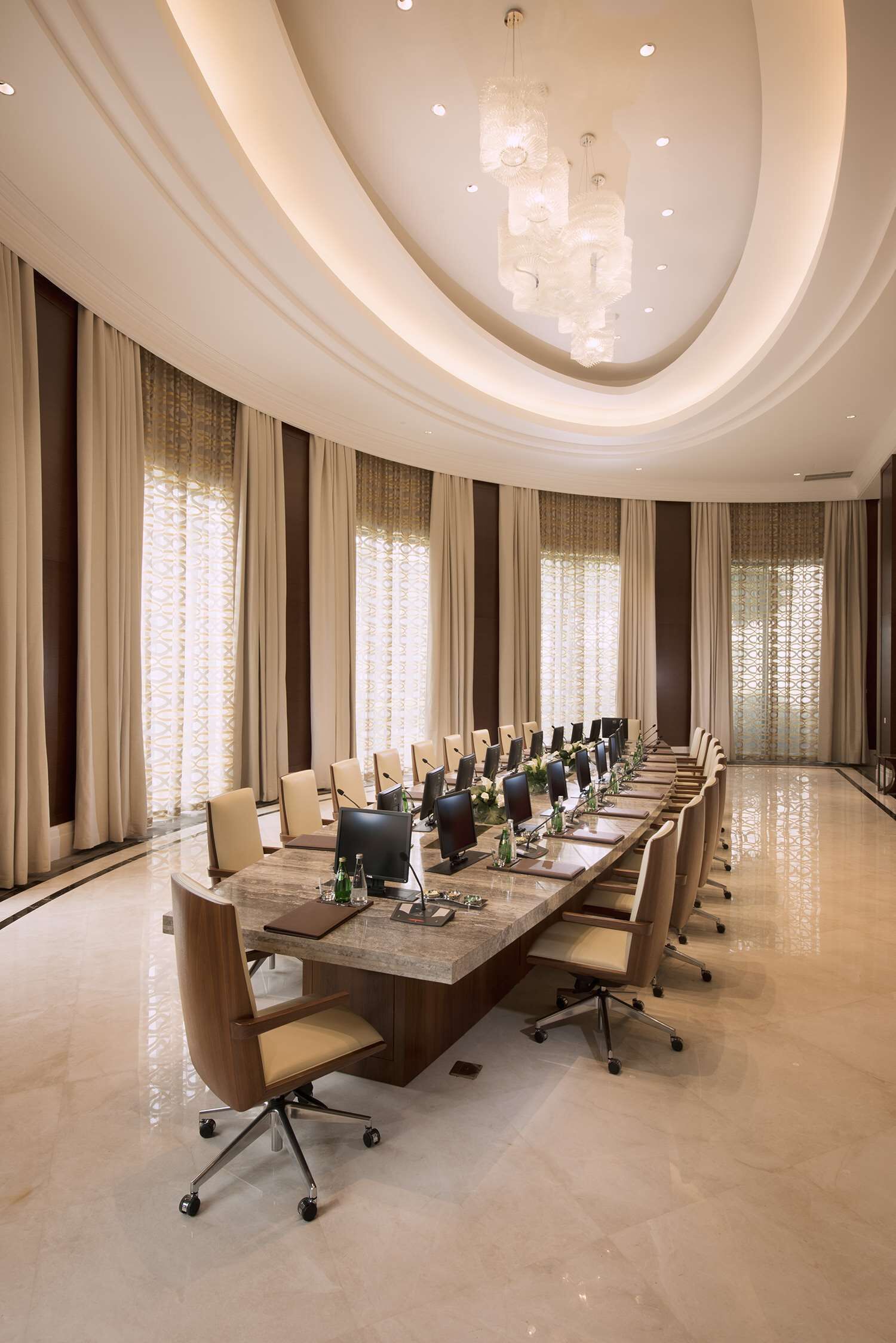 A conference room with a long table, chairs, and a chandelier.