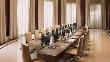 A conference room with a long table, chairs, and a chandelier.