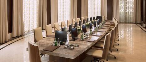 A conference room with a long table, chairs, and a chandelier.