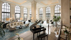 A spacious lobby with a grand piano, comfortable seating, large windows, and elegant decor. - Hilton Haikou Meilan (Haikou)