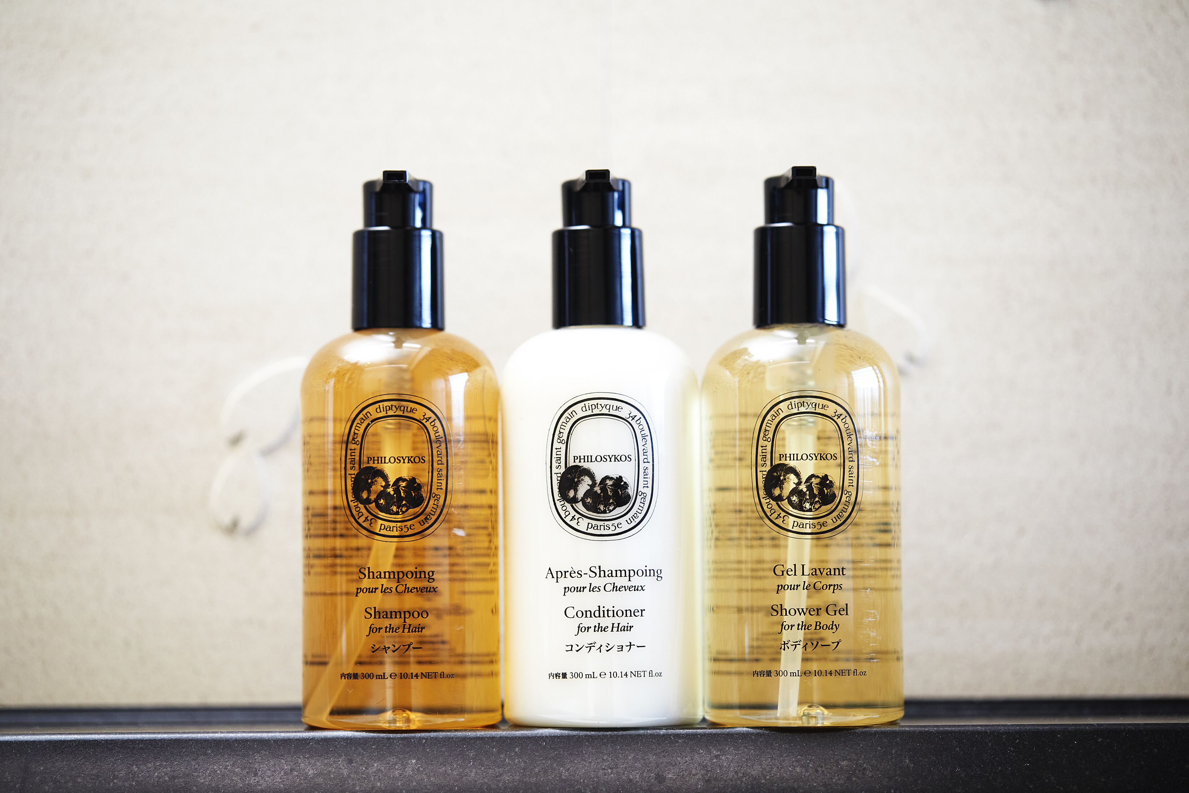 Three bottles of hair care products on a shelf.