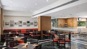Un restaurante amplio con techos altos, varias mesas y sillas.