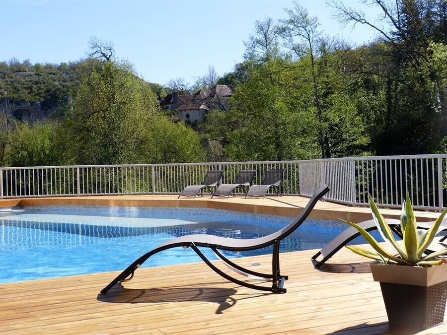Una piscina al aire libre, sillones reclinables de piscina
