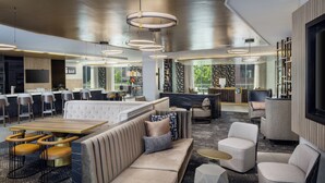 A modern lounge area with a sofa, armchairs, and a bar counter. - Hyatt House Washington DC / Downtown / Convention Center (Washington)