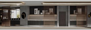 Un intérieur moderne avec un comptoir d’accueil, des œuvres d’art encadrées et une cloison en bois.
