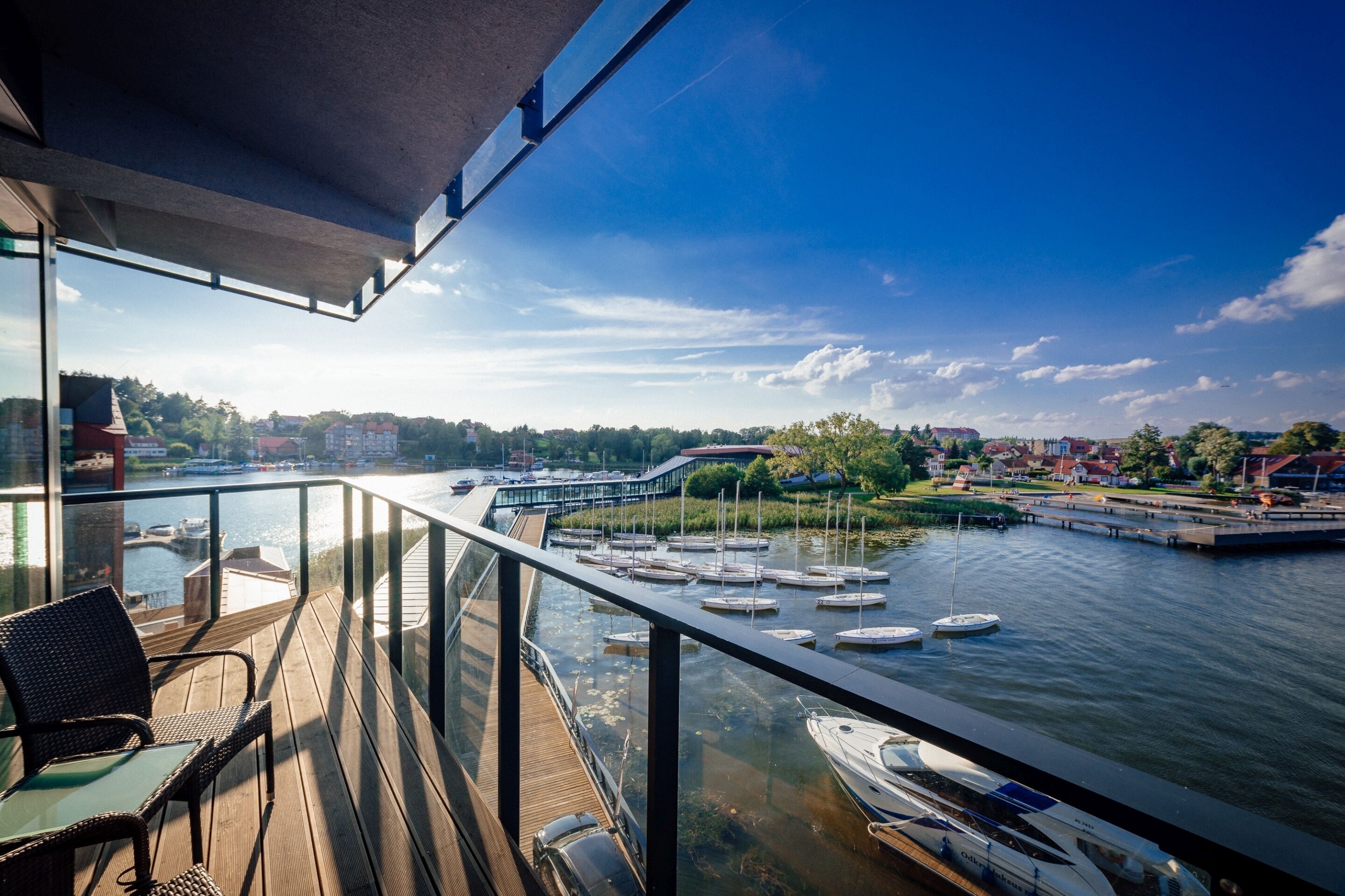 A balcony with a view of a marina and a river.