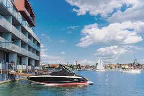 A marina with a yacht docked near a building with multiple balconies.