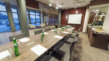 A conference room with a long table, chairs, a whiteboard, and a buffet area.