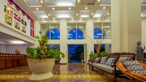 A spacious lobby with a large potted plant, a sofa, and a statue. - La Residence WatBo Hotel (Siem Reap)