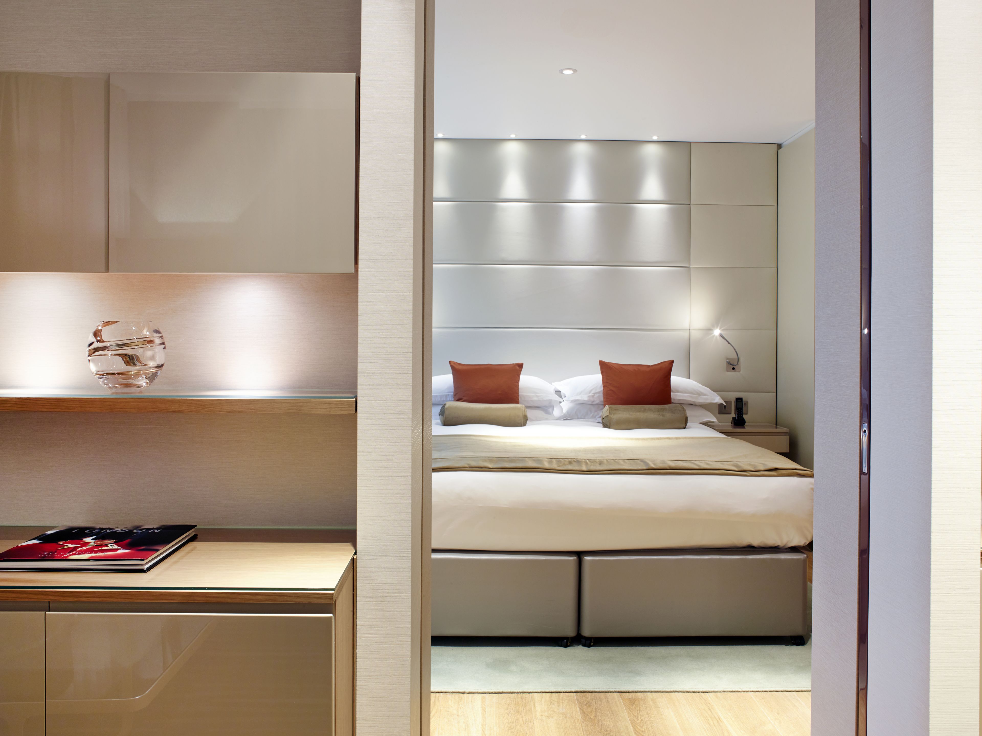 A modern bedroom with a large bed, a bedside table, and a nightstand.