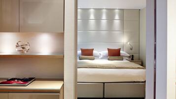 A modern bedroom with a large bed, a bedside table, and a nightstand.