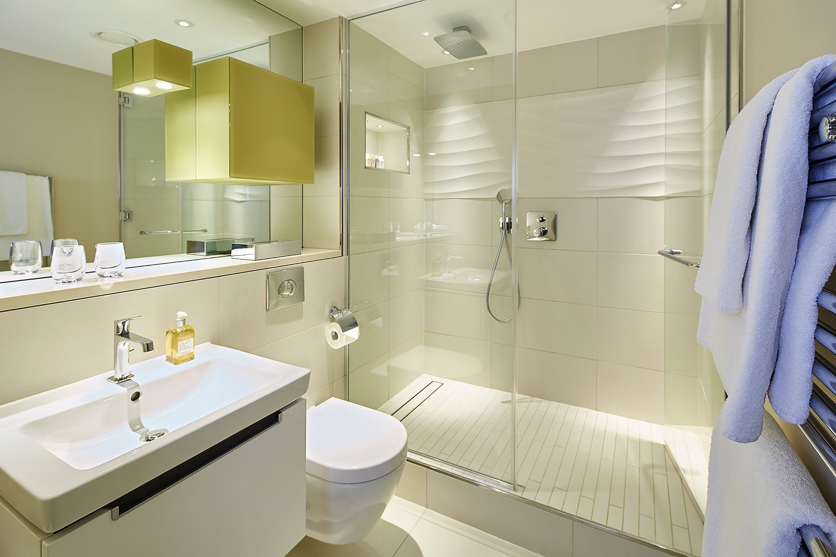 Une salle de bain moderne avec une douche à parois de verre, un lavabo blanc et des toilettes.