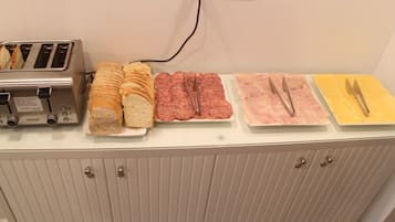 Un bufé de desayuno con diversas opciones de comida y un tostador.
