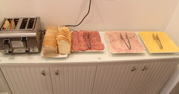 Un bufé de desayuno con diversas opciones de comida y un tostador.