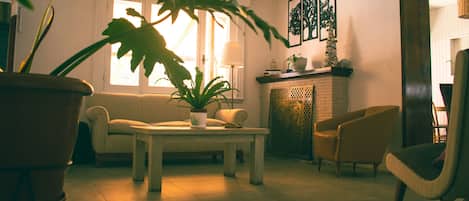 A living room with a sofa, a coffee table, and a potted plant.