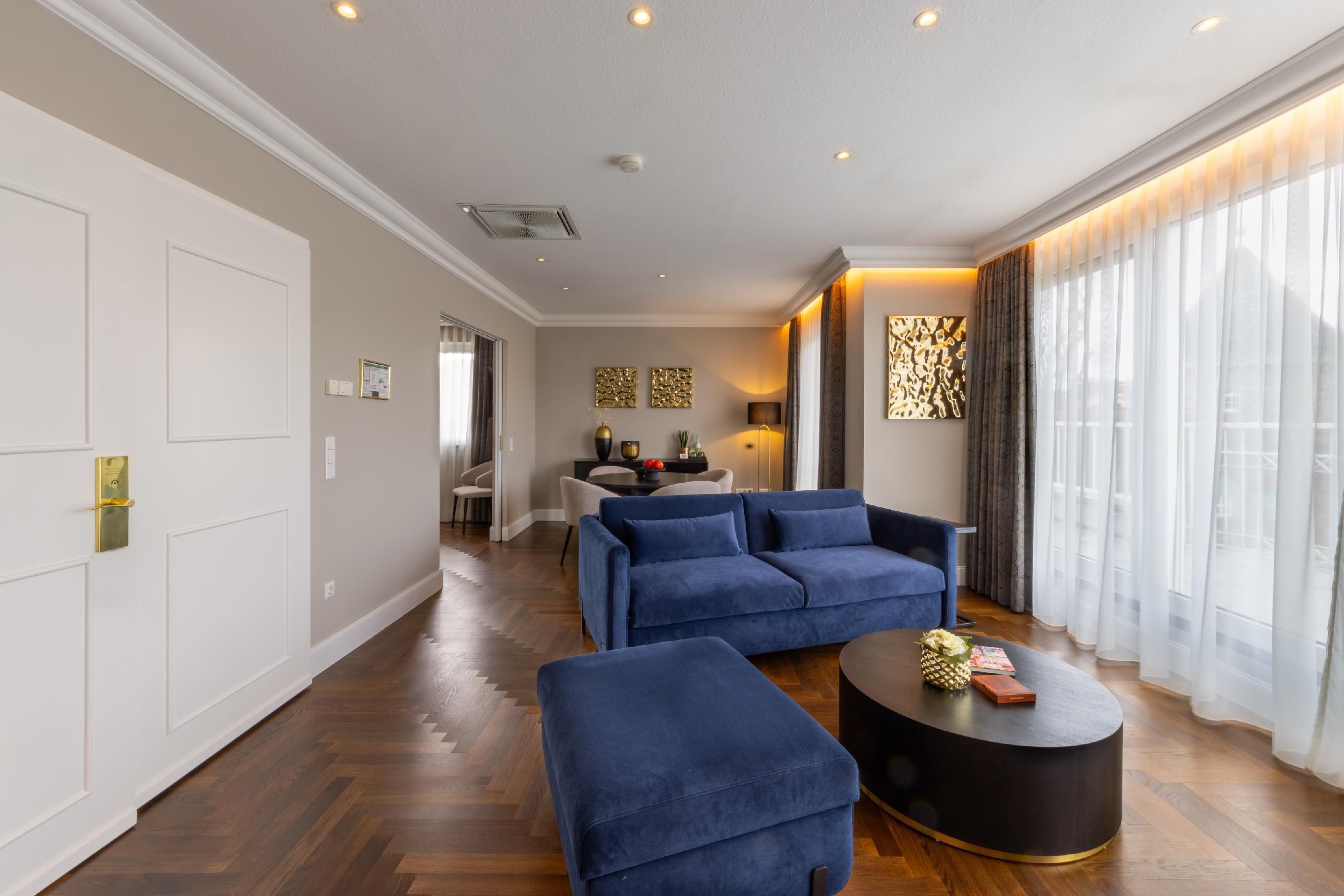 Een moderne woonkamer met een zithoek, een salontafel en een eethoek op de achtergrond.
