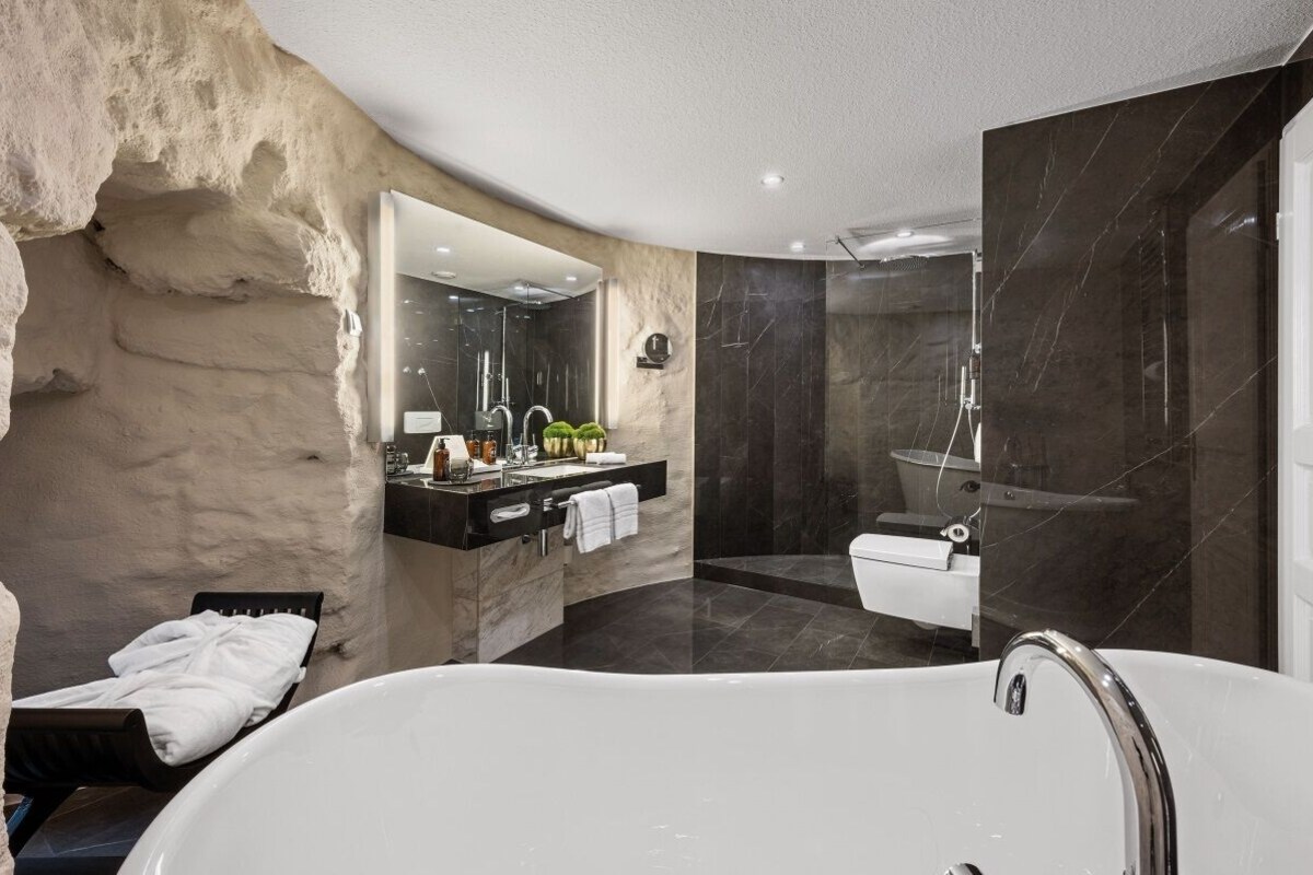 A modern bathroom with a freestanding bathtub, a vanity with a mirror, and a shower area.