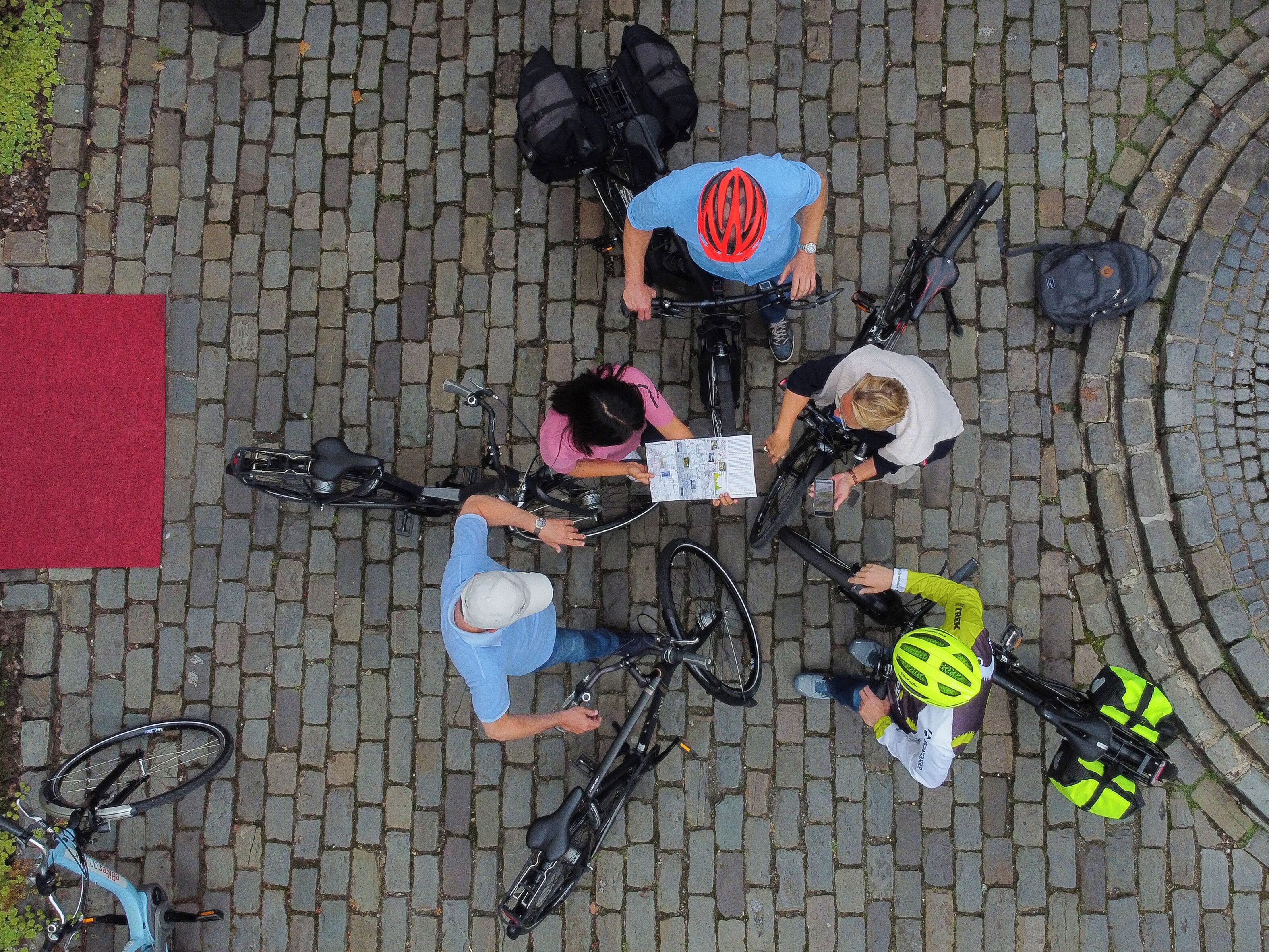 A group of cyclists on a cobblestone street.