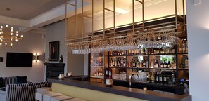 A bar area with a modern design, featuring a counter with a variety of liquor bottles and glasses. - Parkhotel Engelsburg (Recklinghausen)