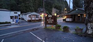 A sign for the Russian River Inn with a road in the foreground.