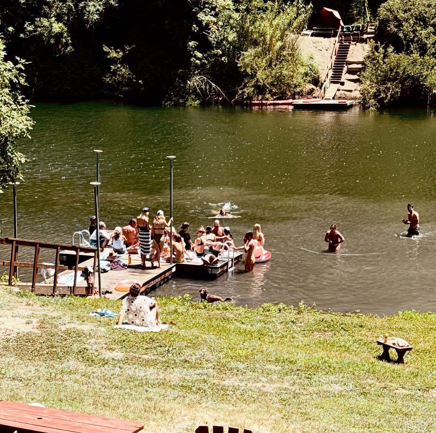 A riverside area with people swimming and relaxing.