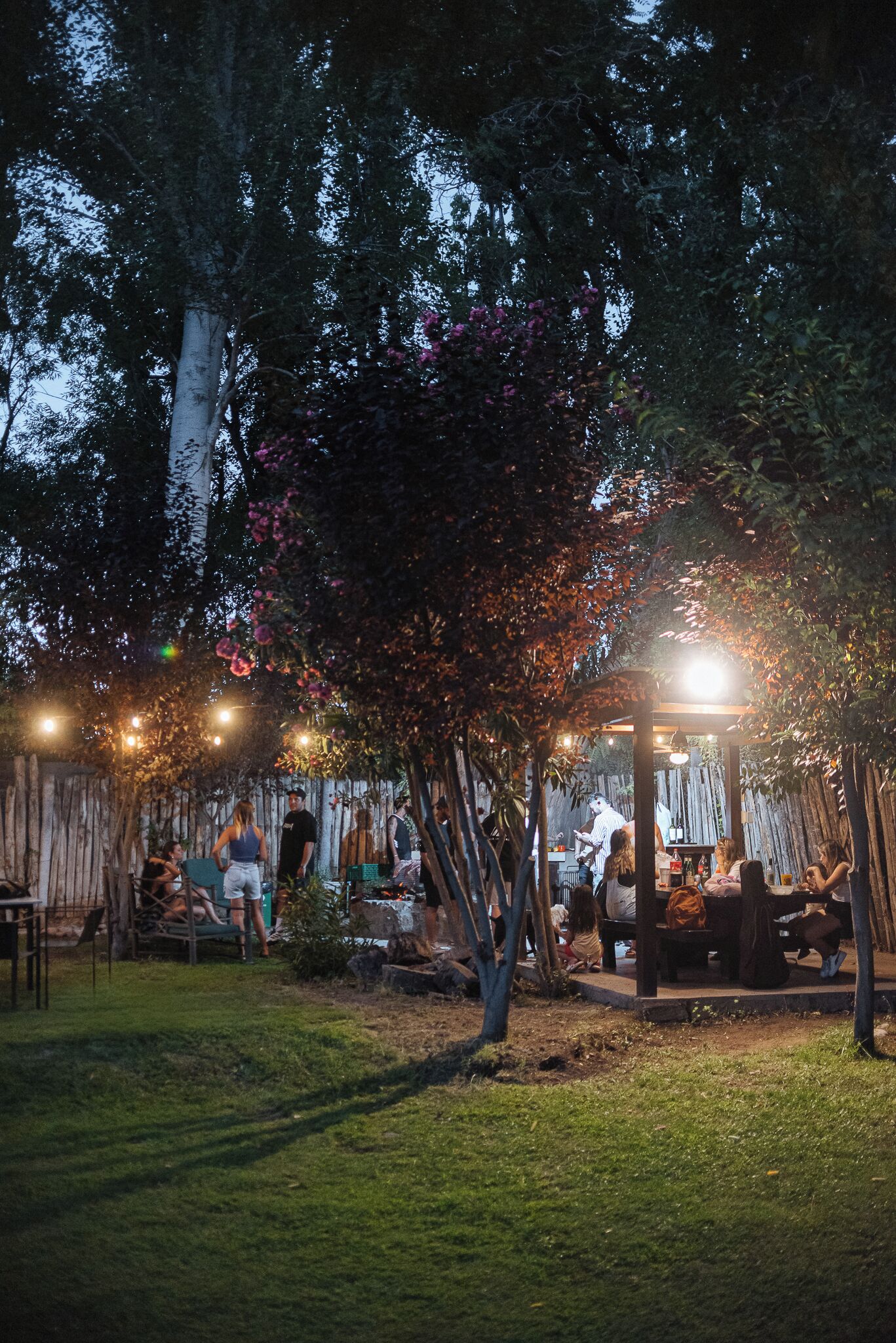 An outdoor patio area with a wooden pergola, tables, and chairs.