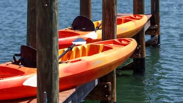 Dos kayaks atados a un muelle de madera sobre el agua.