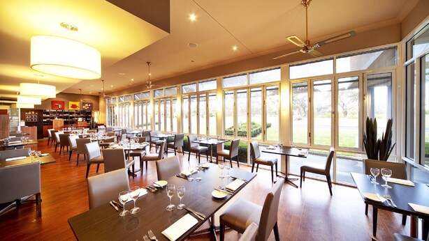 A spacious restaurant with large windows, modern lighting, and a variety of seating arrangements. - Century Inn (Traralgon)