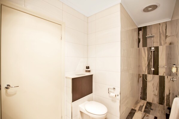 A modern bathroom with a toilet, sink, and shower. - Century Inn (Traralgon)