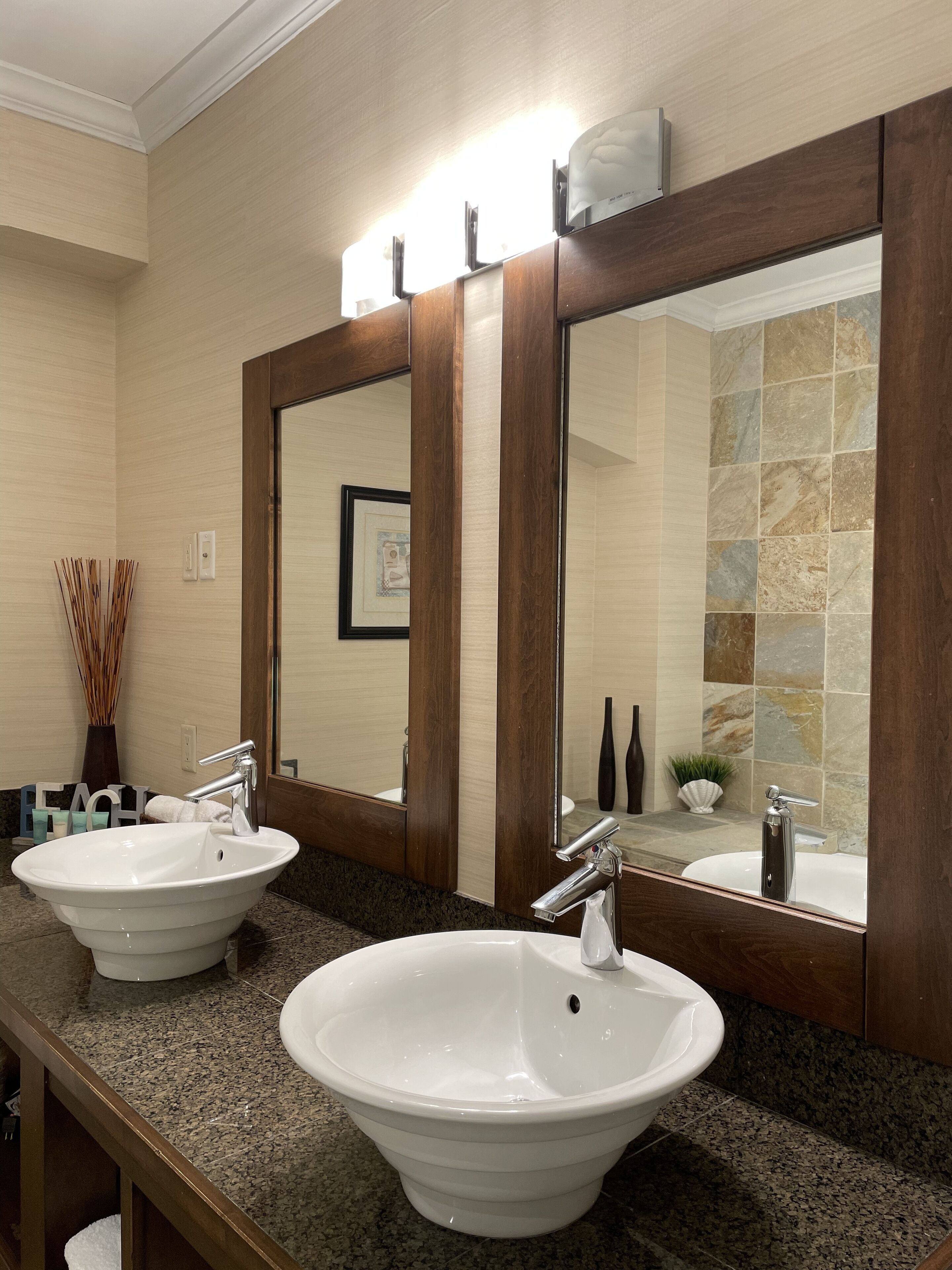 Une salle de bain avec deux lavabos, un grand miroir et un porte-serviettes.