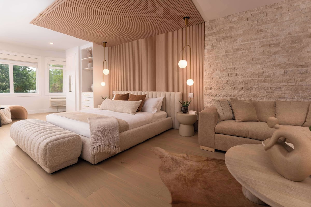 A modern bedroom with a large bed, a sofa, and a decorative sculpture.