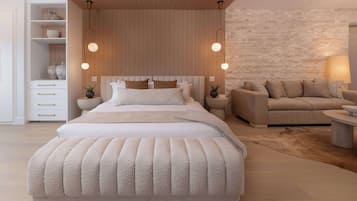 A modern bedroom with a large bed, a sofa, and a nightstand.
