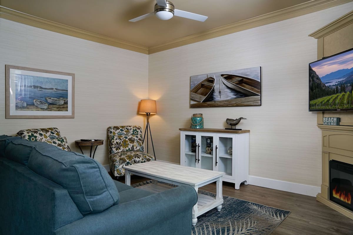 A living room with a sofa, a coffee table, a lamp, a cabinet, and a fireplace.