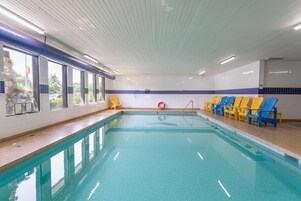 Una piscina techada, sillones reclinables de piscina