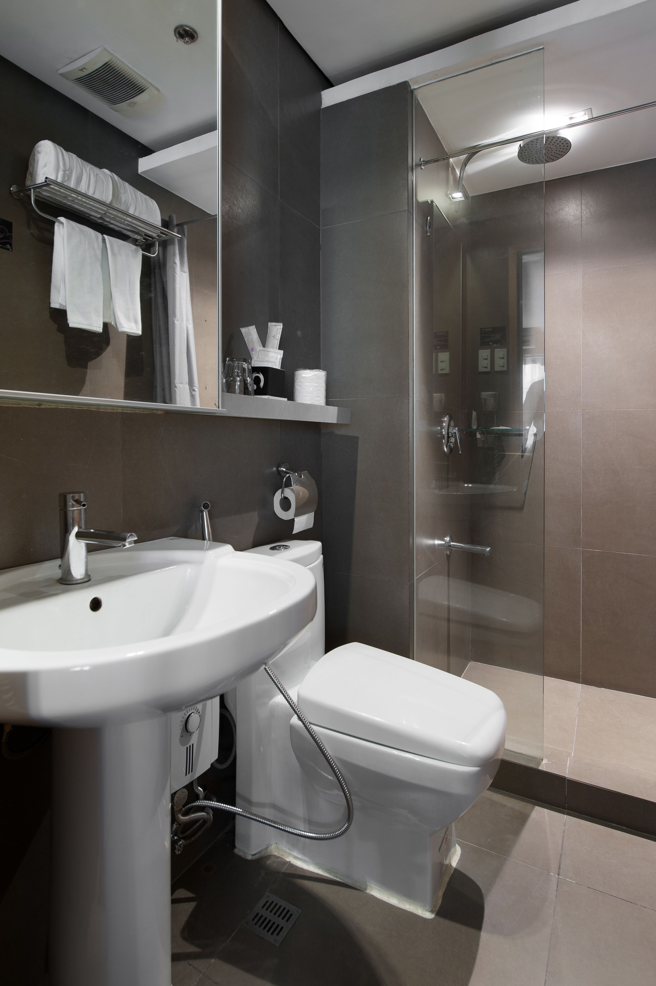 Ein modernes Badezimmer mit einer Duschkabine aus Glas, einem weißen Waschbecken und einer Toilette.