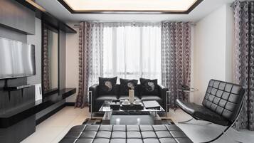 Habitación Deluxe, 2 habitaciones | Zona de estar | Televisión LED de 42 pulgadas con canales por satélite, una televisión