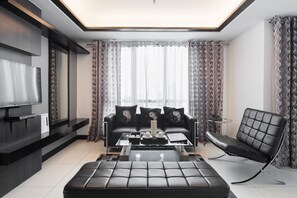 Habitación Deluxe, 2 habitaciones | Área de sala de estar | Televisión LED de 42 pulgadas con canales vía satélite y televisión 