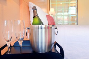 A metallic bucket with a bottle of champagne and two empty glasses on a tray.