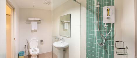 Une salle de bain avec des toilettes, un lavabo et une douche.